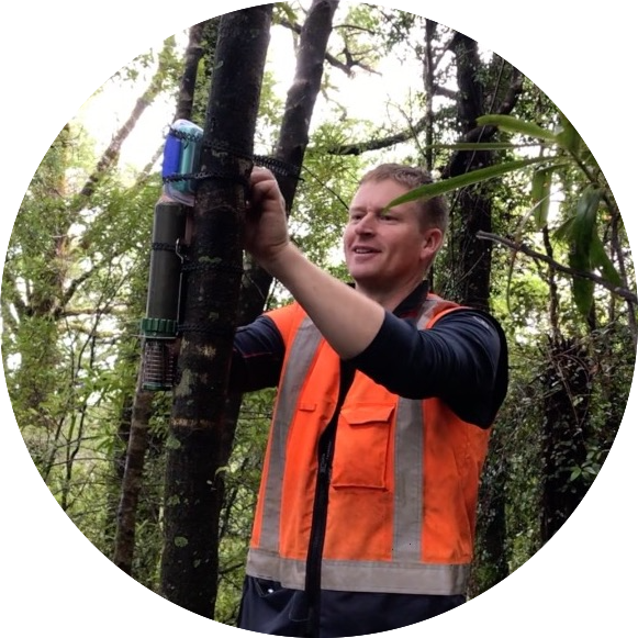 Image shows acoustic recorders being attached to a tree in the field.